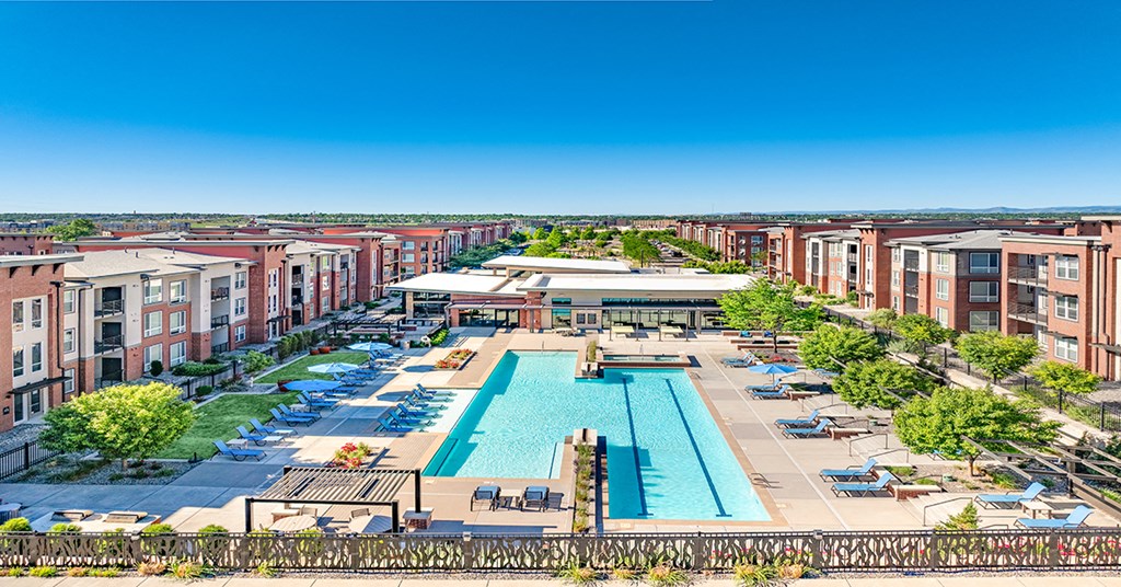A large swimming pool is surrounded by apartment buildings.