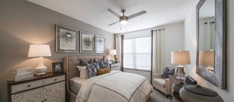 a bedroom with a large bed and a ceiling fan