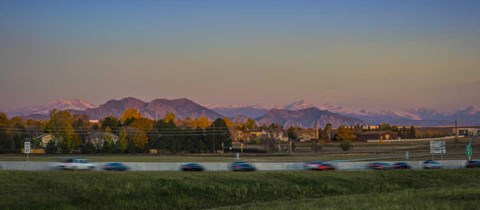 a city with mountains in the background and speeding traffic
