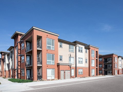 a row of brick apartment buildings on the side of a street