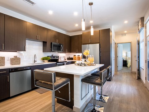 a kitchen with a large island with two chairs