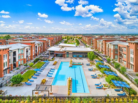 an aerial view of a swimming pool in front of apartments