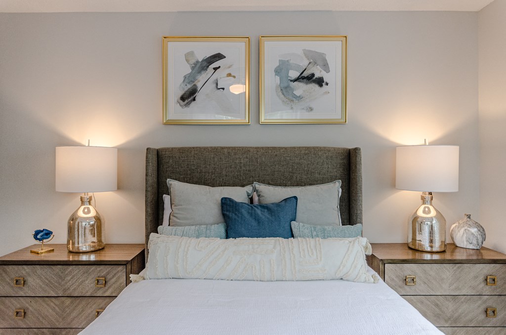 a bedroom with a bed and two paintings on the wall above it