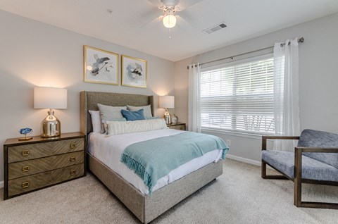 a bedroom with a bed and a chair and a window