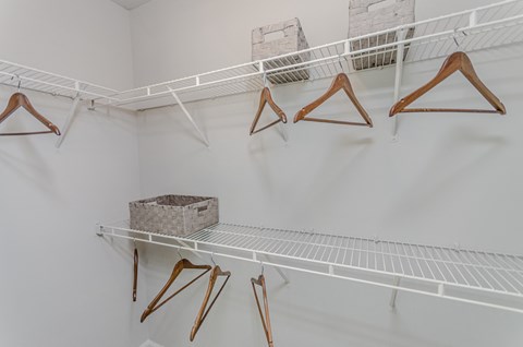 a closet with shelves and hooks and a basket on a shelf