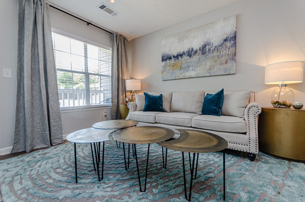 a living room with a couch and three tables
