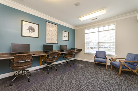 a room with a desk and chairs and a window