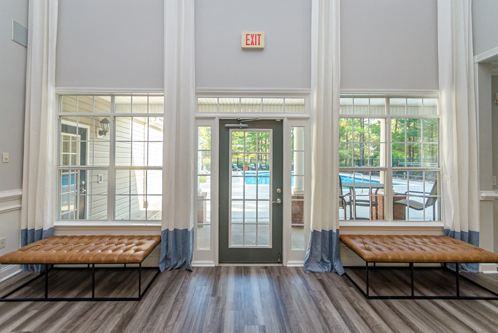 a lobby with benches and a door to a swimming pool