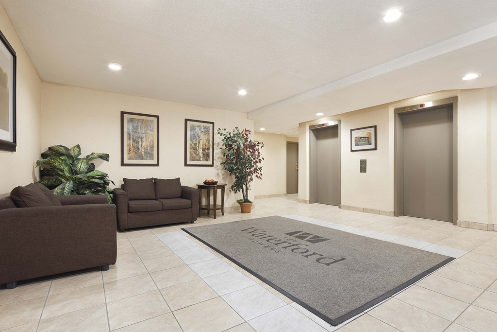 a lobby with couches and a rug in front of two doors