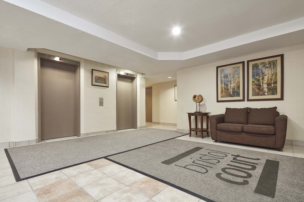 a living room with a couch and a rug in front of three doors