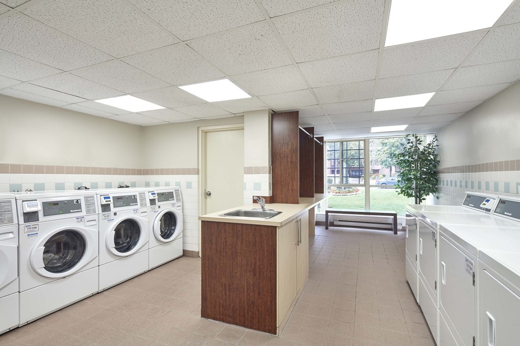 a laundry room with washers and dryers and a sink