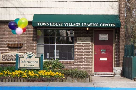 a building with a red door and a green awning