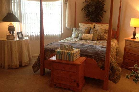 a bed room with a neatly made bed and a table