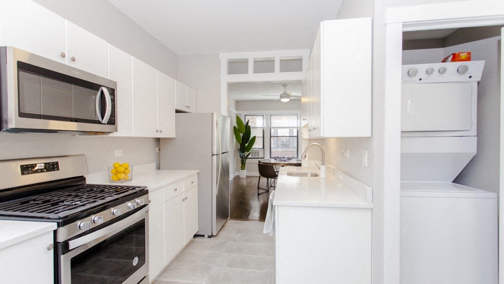 a white kitchen with stainless steel appliances and white cabinets