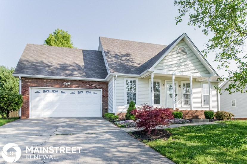a white house with a white garage door and a lawn