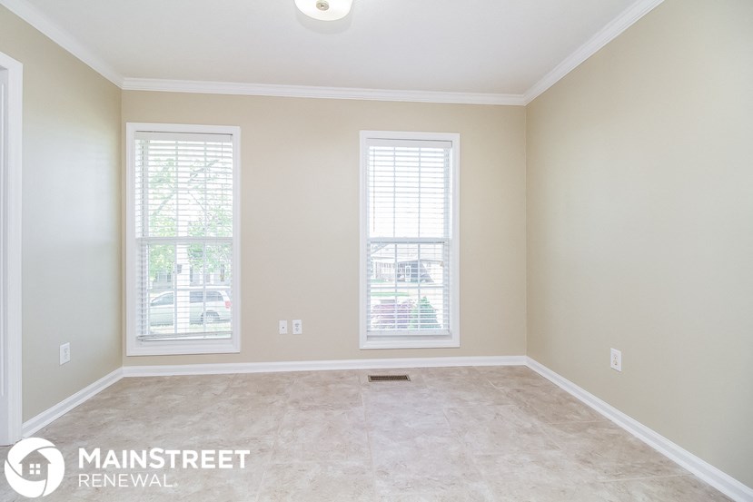 a empty room with two windows and a tile floor