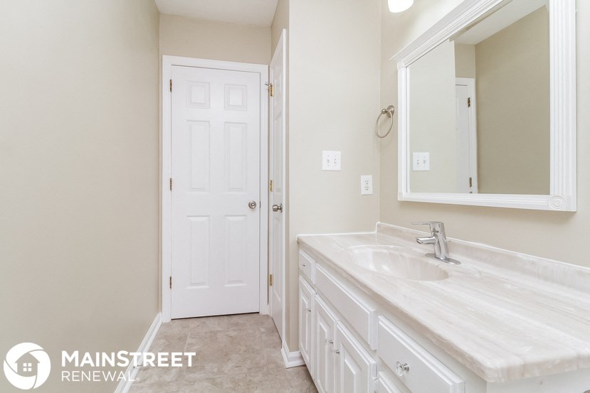 a bathroom with a sink and a mirror and a white door