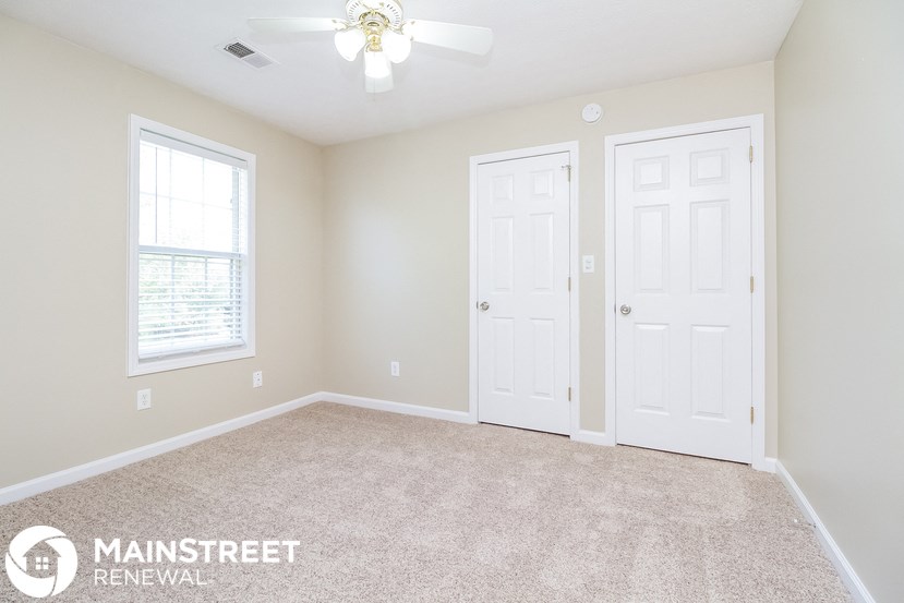 the master bedroom has a carpeted floor and two closets