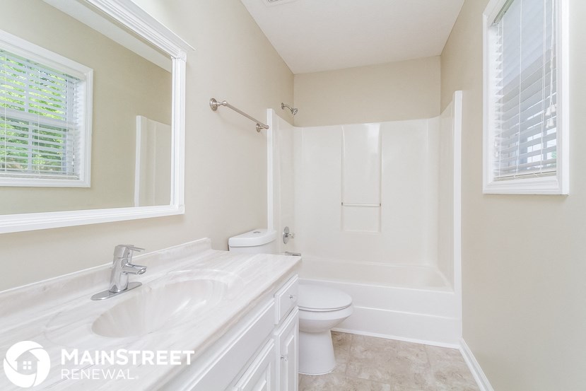 a white bathroom with a white toilet and a tub and a sink
