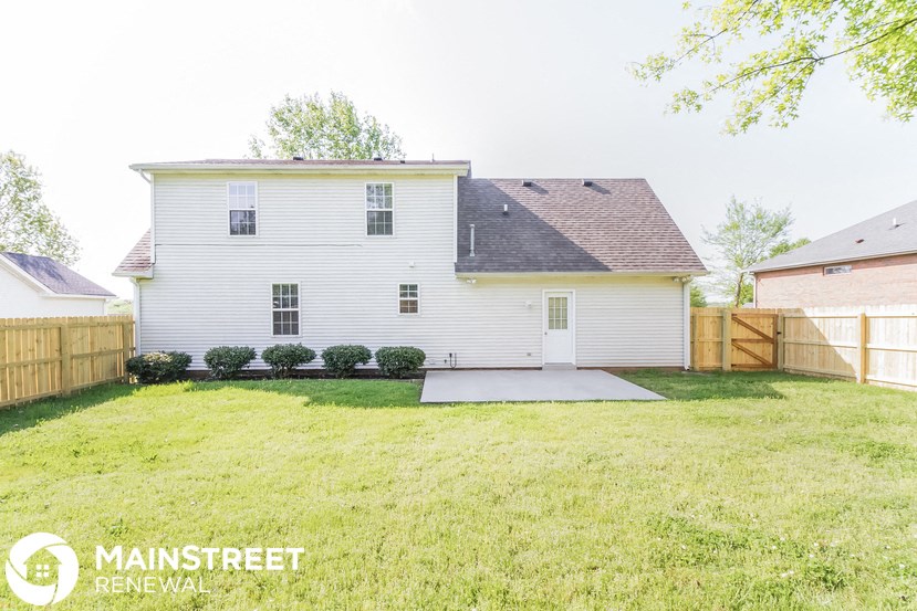 a white house with a yard and a wooden fence