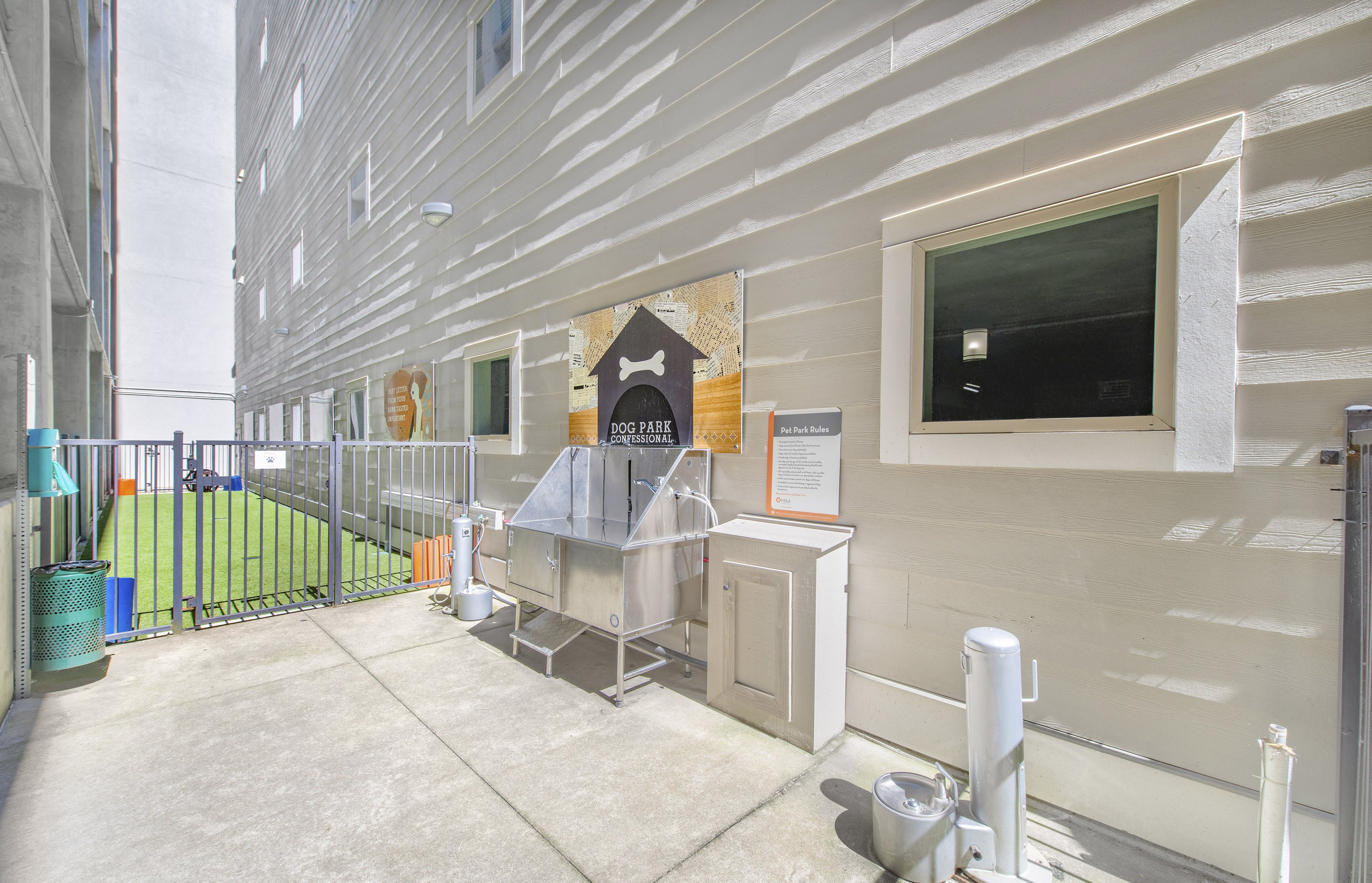 a fenced in area with a sink in the corner of a building