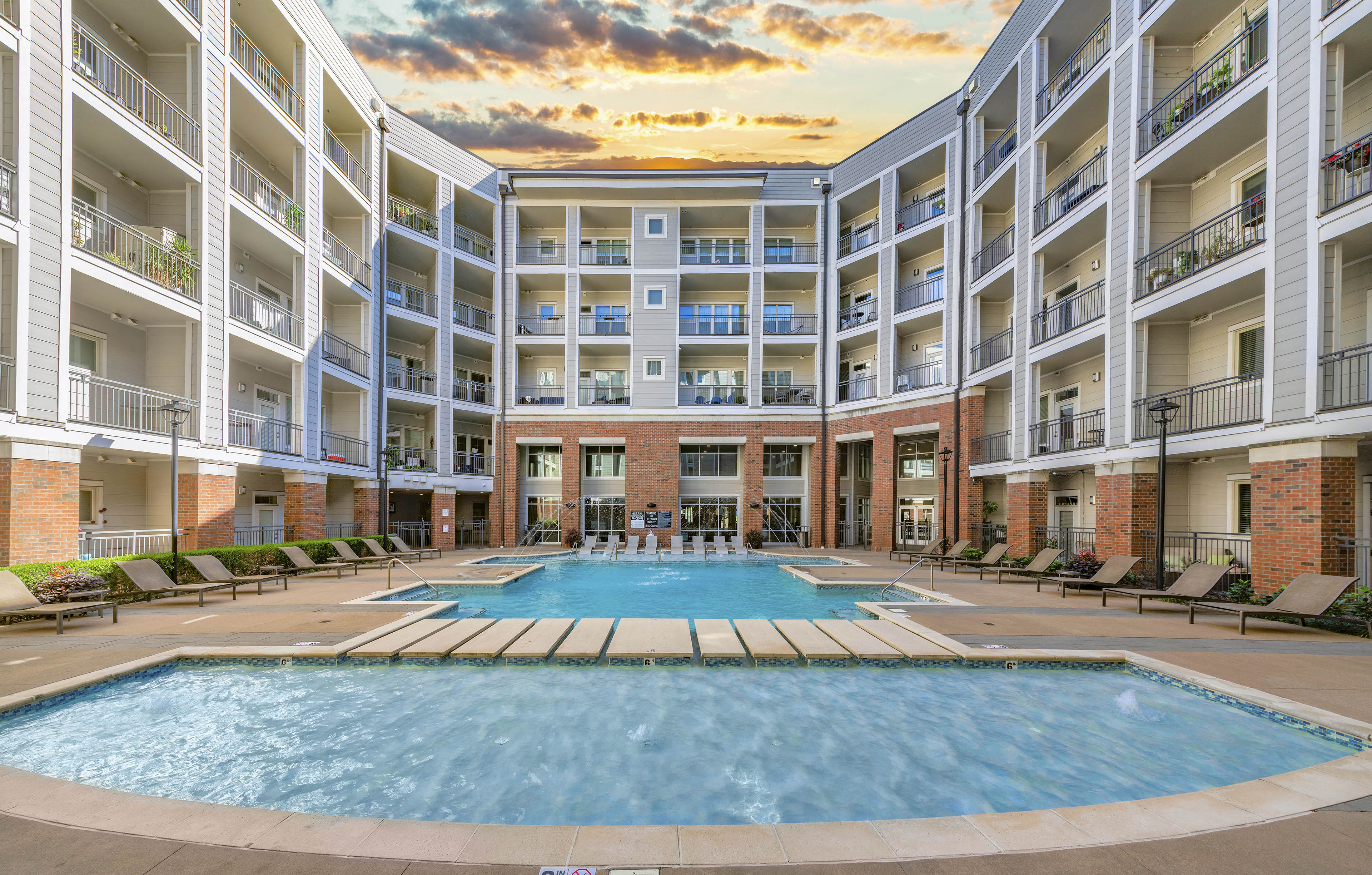 a large swimming pool in front of an apartment building