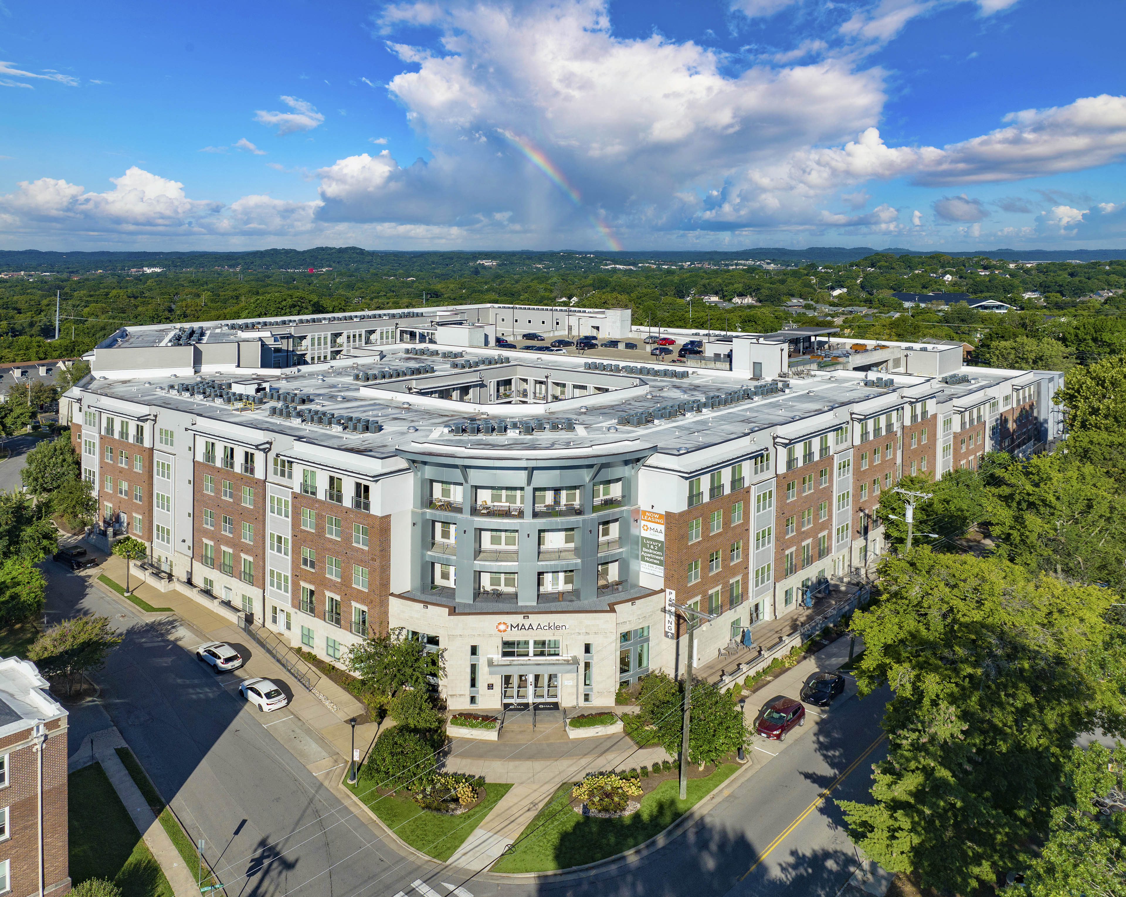 an aerial view of a large building with a rainbow in the background