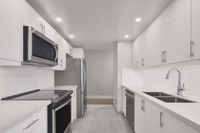 a kitchen with white cabinets and a sink and a microwave
