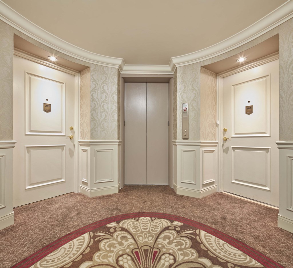 a hallway with white walls and a rug
