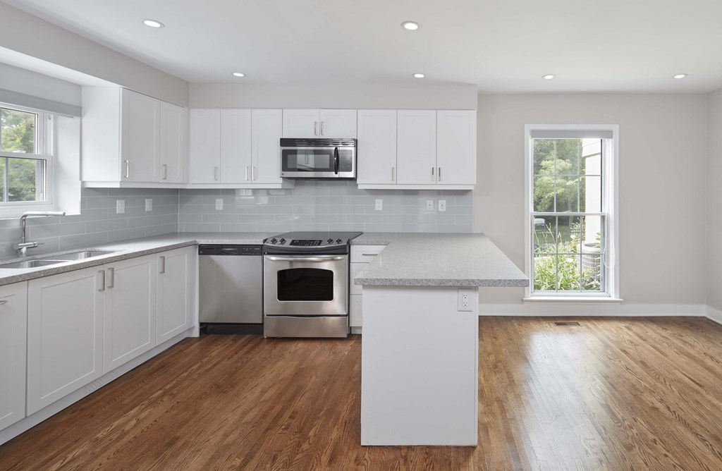 a kitchen with white cabinets and stainless steel appliances