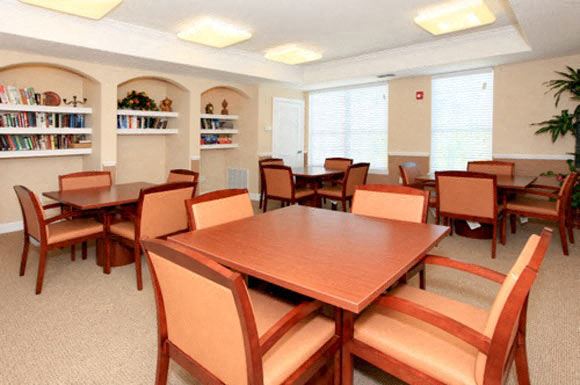 a room with a table and chairs and a book shelf