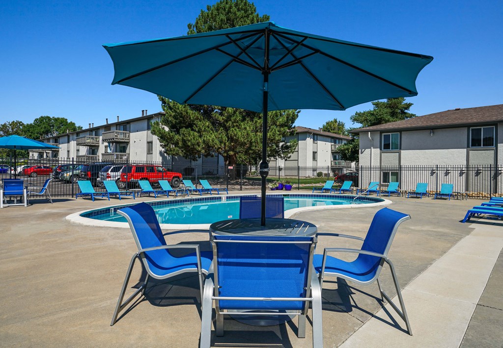 our apartments have a pool and a table with chairs and an umbrella