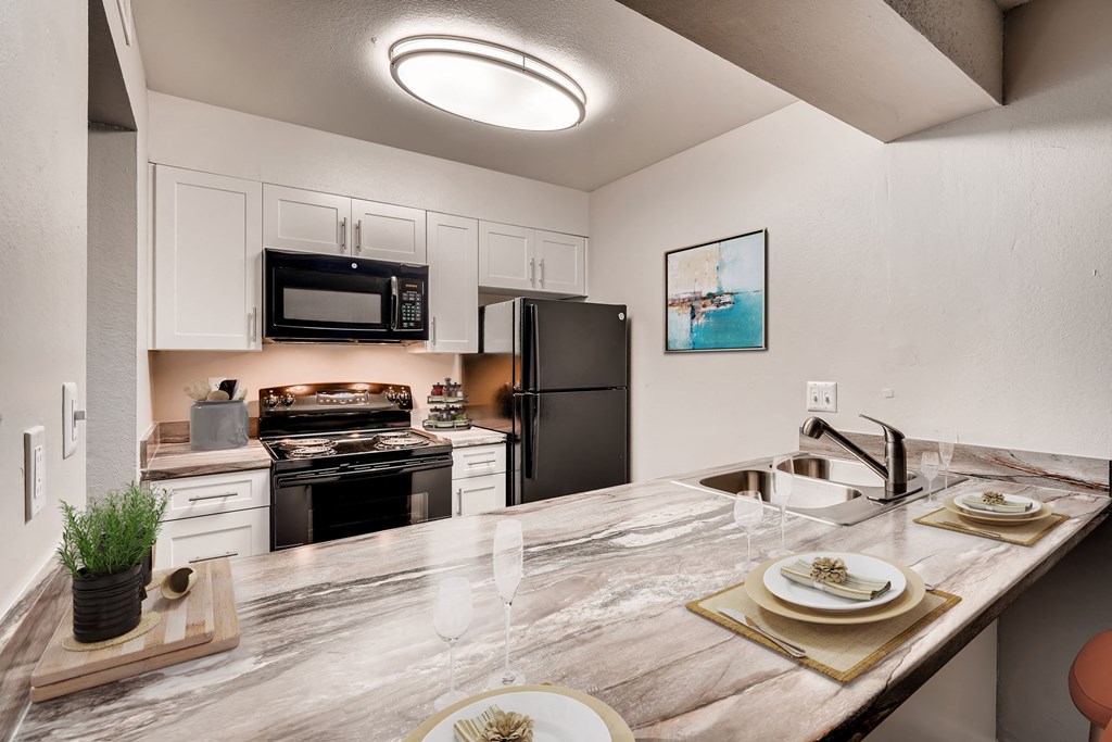 a kitchen with a marble counter top and a sink