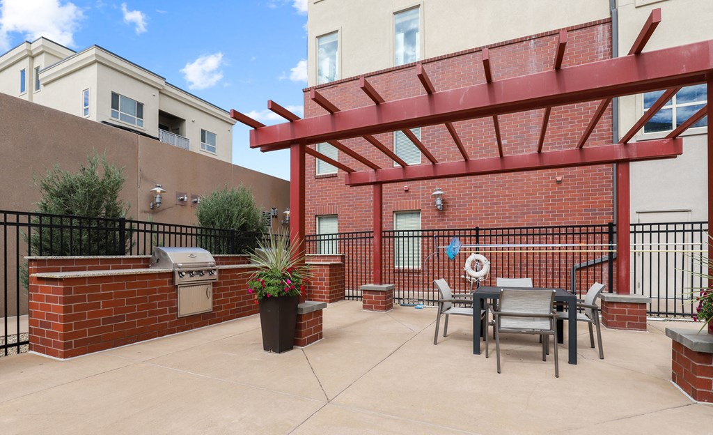 our apartments have a patio with a table and chairs and a grill