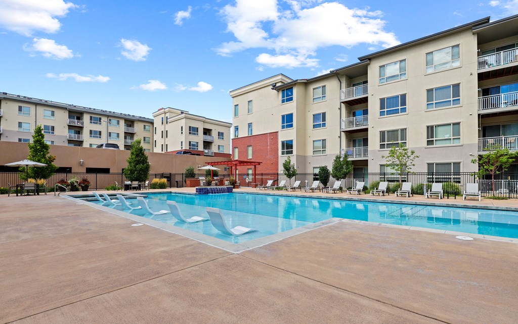 a swimming pool with an apartment building in the background