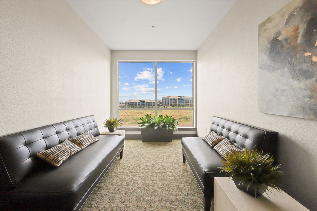 a living room with leather couches and a large window