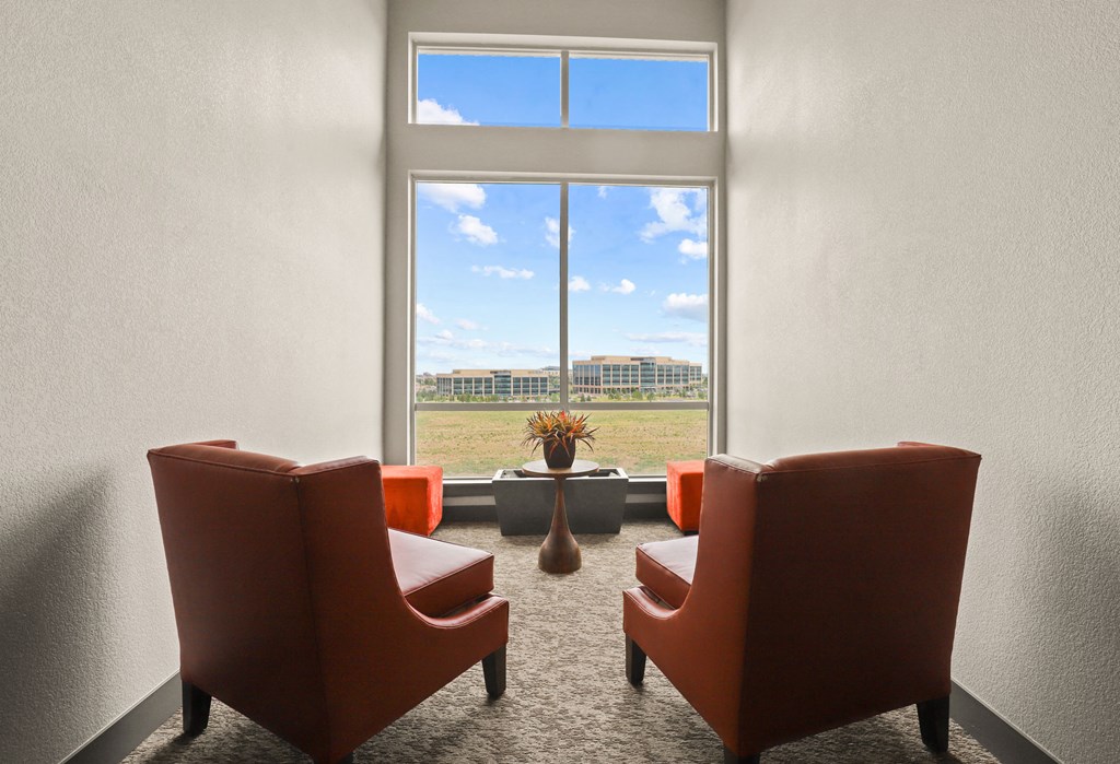 a room with chairs and a window with a view of a field