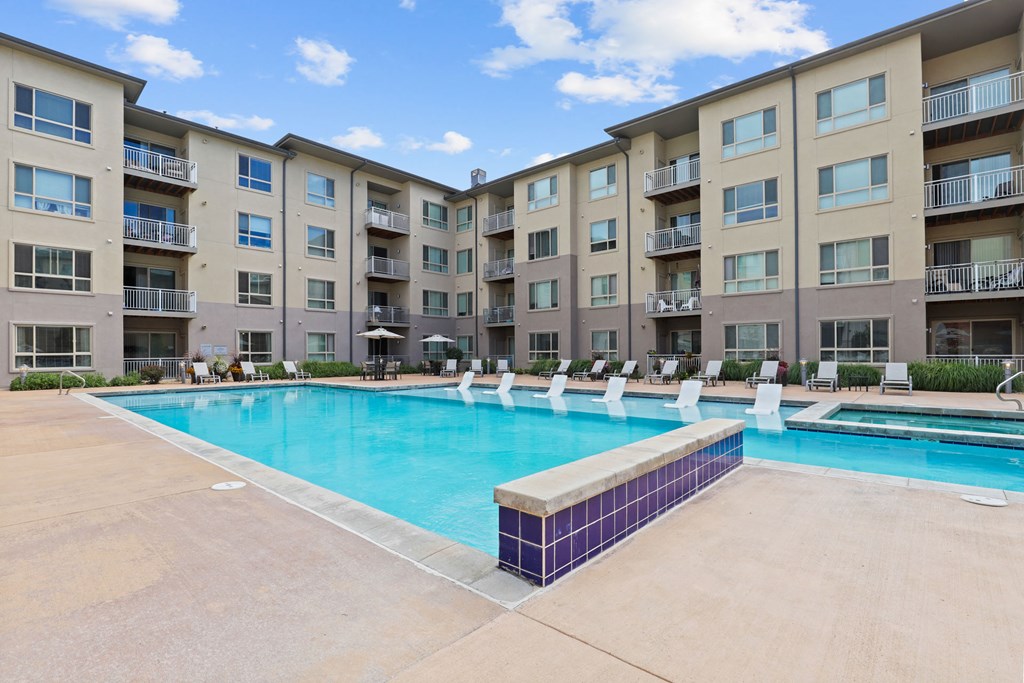 a swimming pool with an apartment building in the background