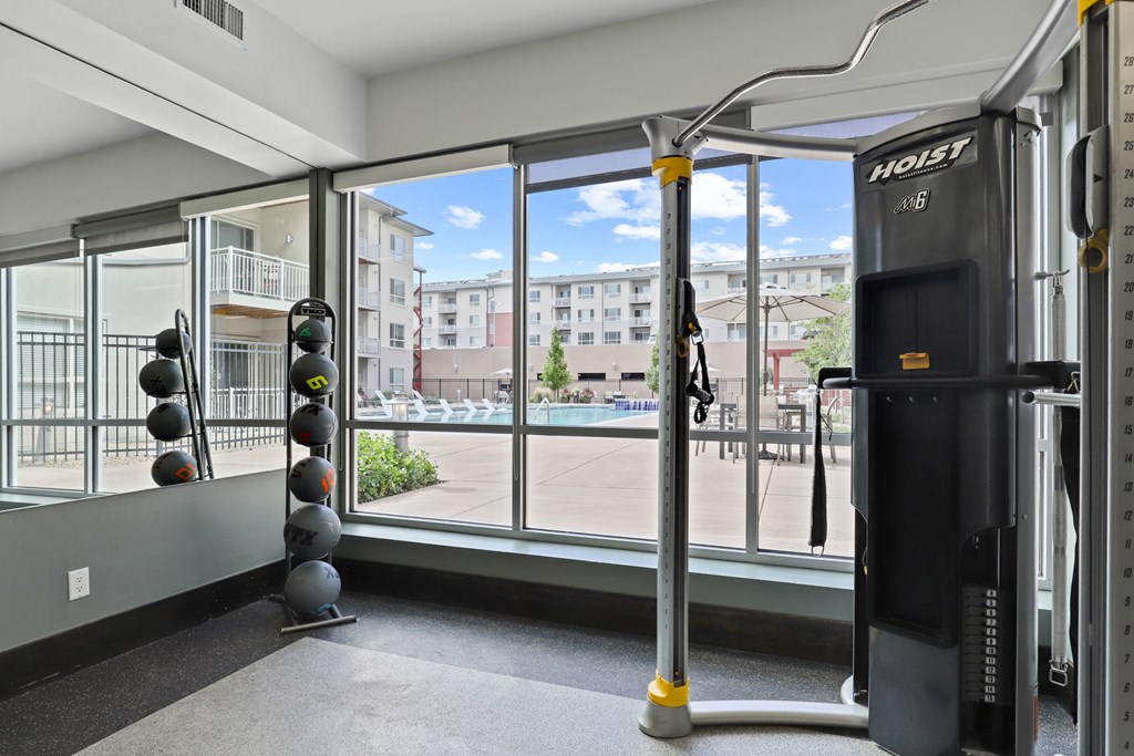 a gym with a view of a pool and a large window