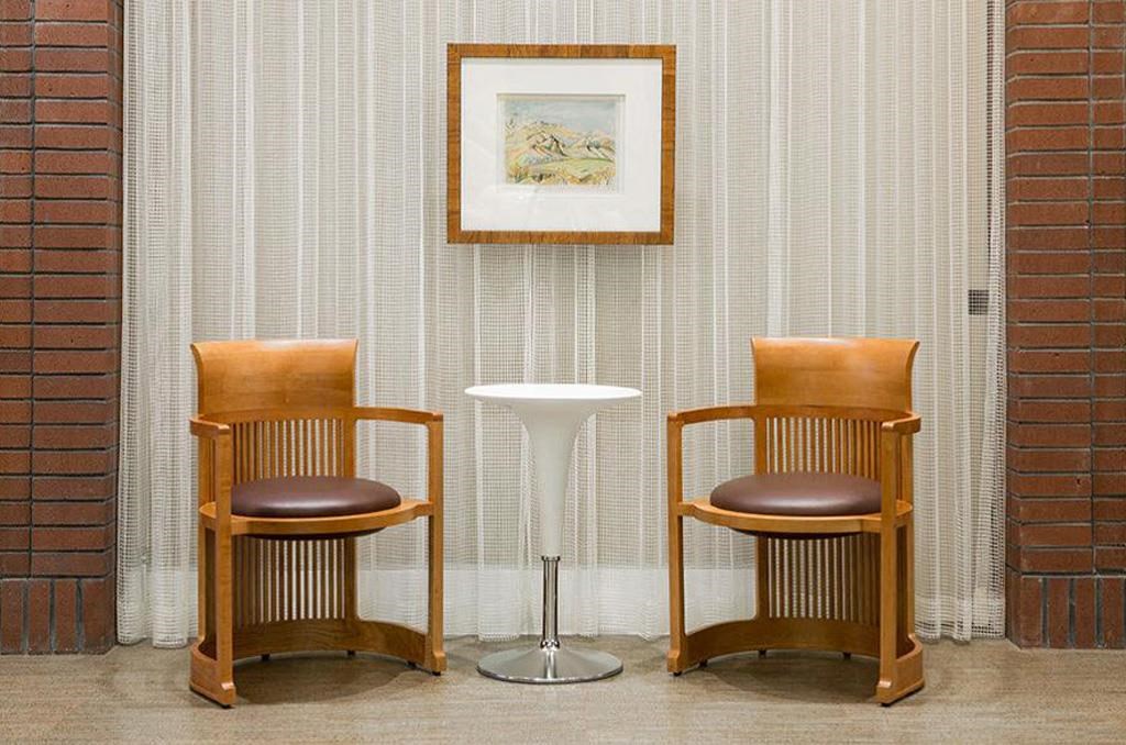 two chairs and a table in front of a brick wall