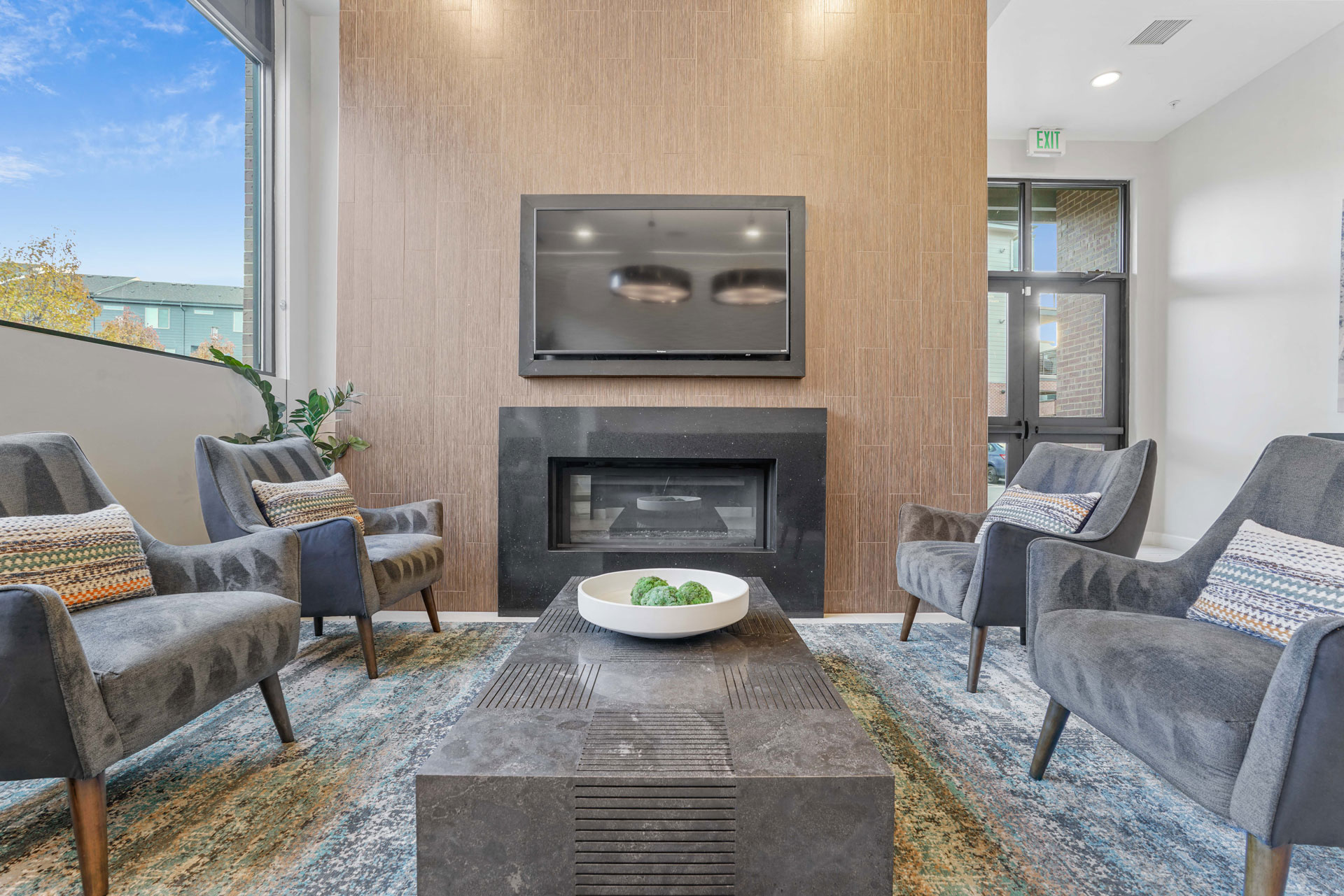a living room with a fireplace and chairs and a table