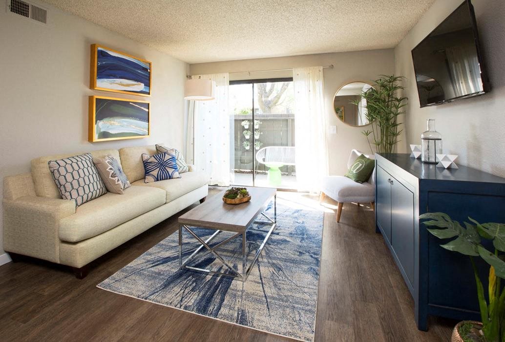A living room with a couch, a coffee table, and a painting on the wall.