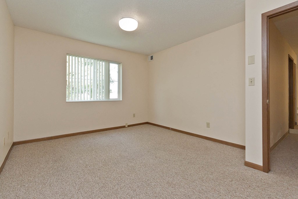 an empty living room with a window and a door