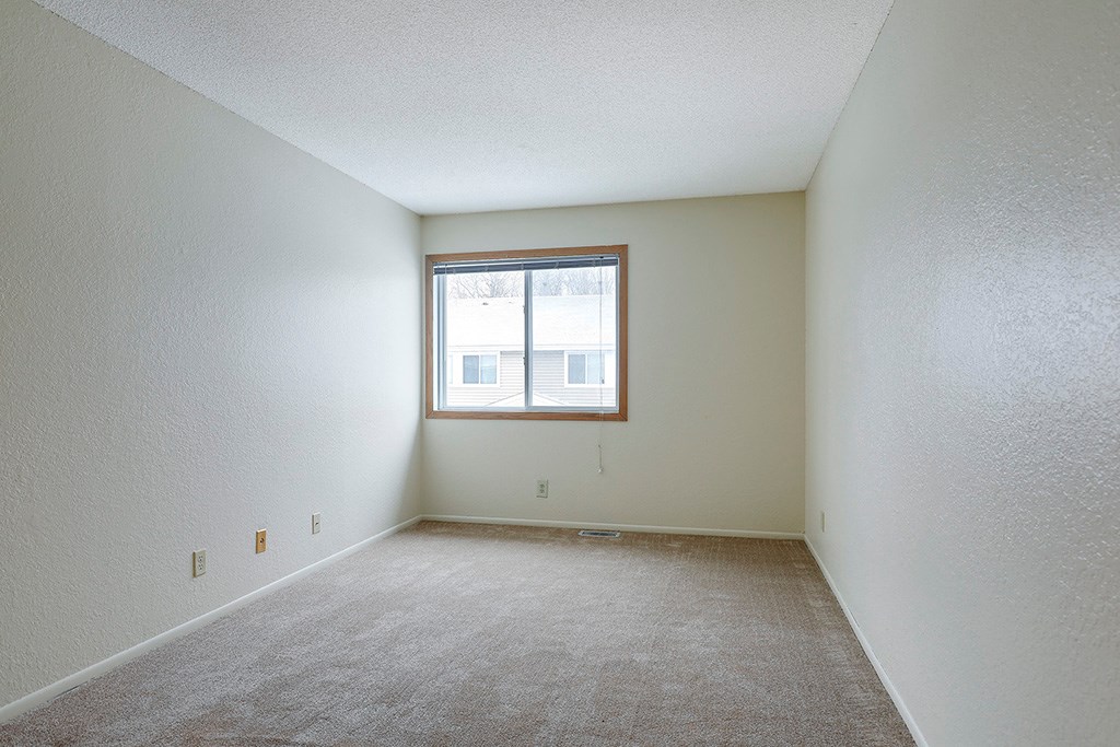 the living room of an empty apartment with a window