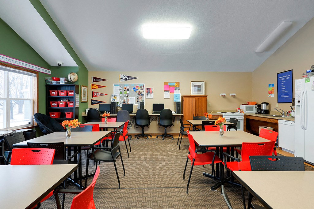 a dining room with tables and chairs and a kitchen