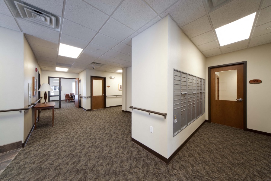a lobby area of a building with a hallway and a door
