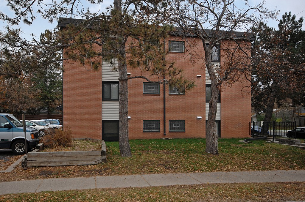 a brick building with trees in front of it