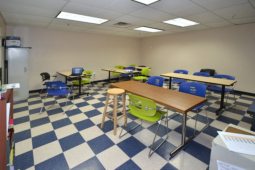 a classroom with desks and chairs and a checkered floor