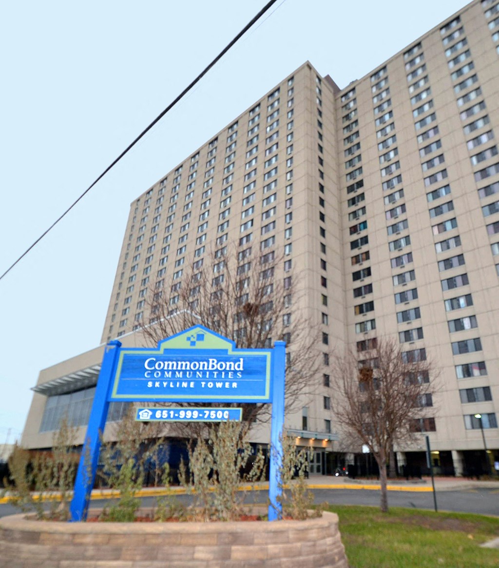 a blue sign in front of a tall building