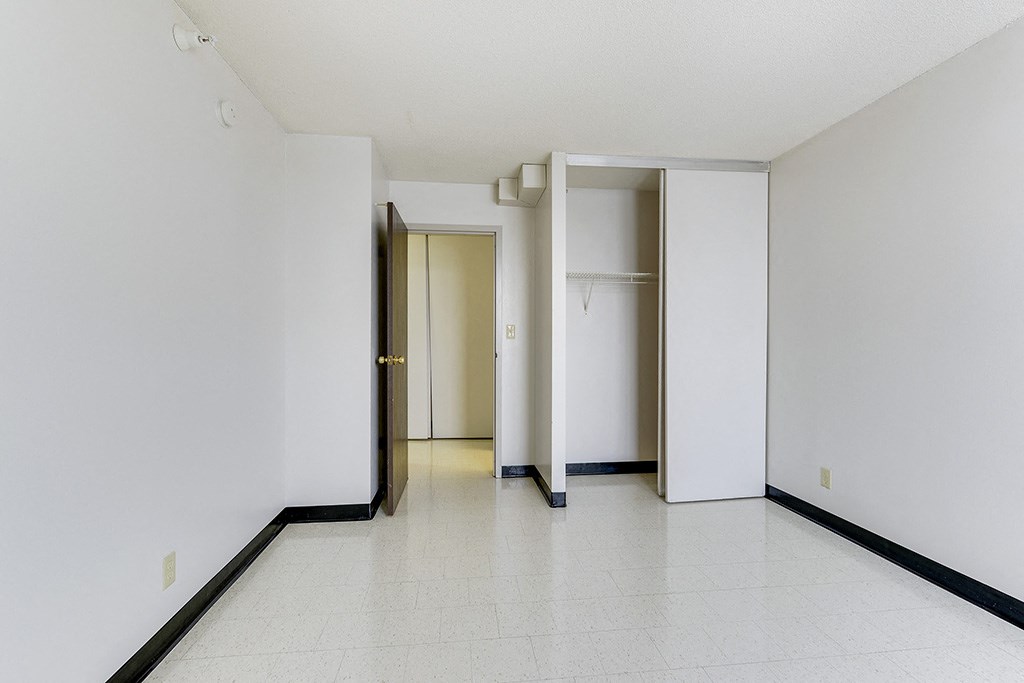 an empty room with white walls and sliding doors